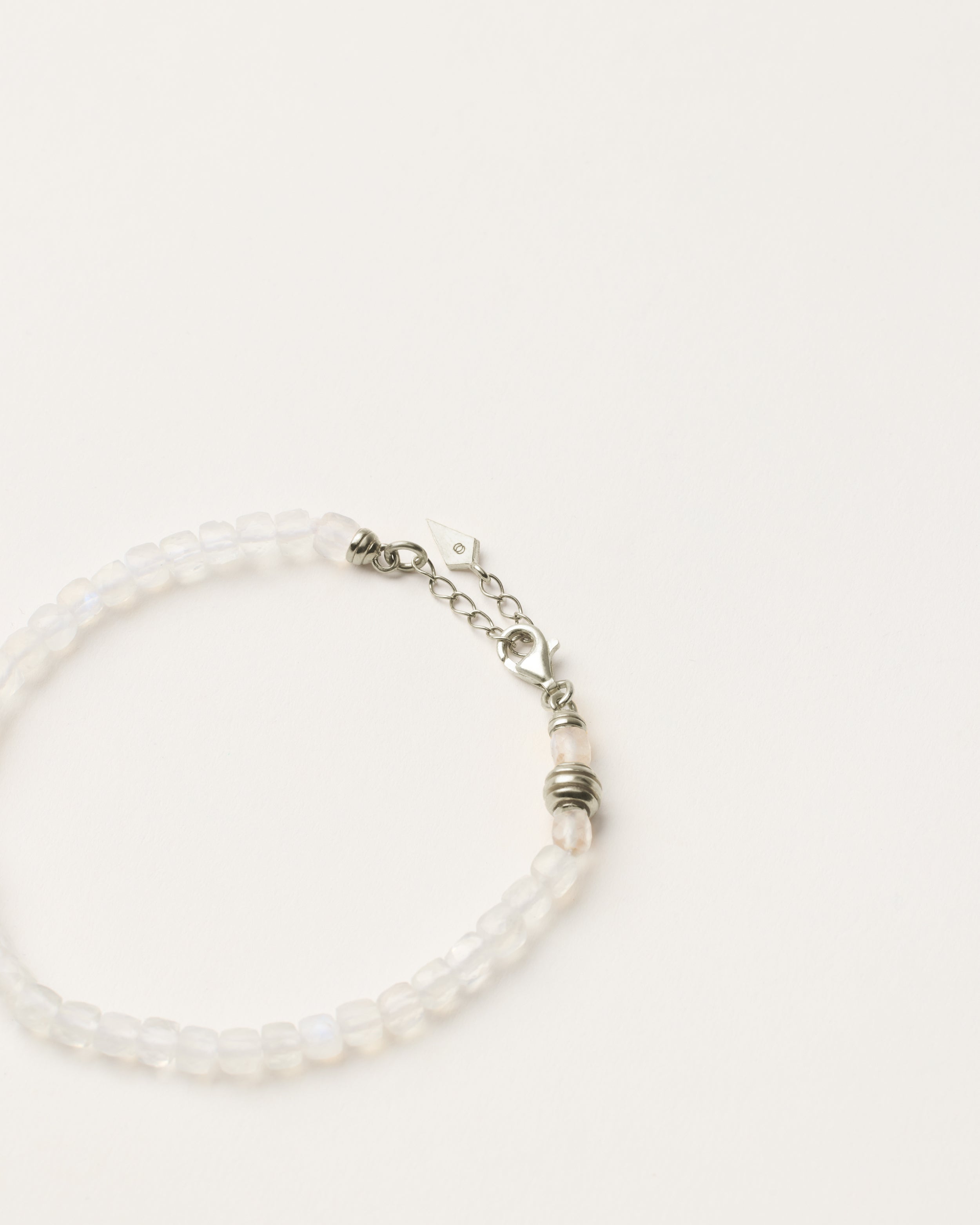ETERNA LUNOR Moonstone bracelet with polished silver spiral bead, 4 cm extension chain and clasp, arrowhead-shaped fantasy signature, and 4 mm faceted moonstone bead strand.