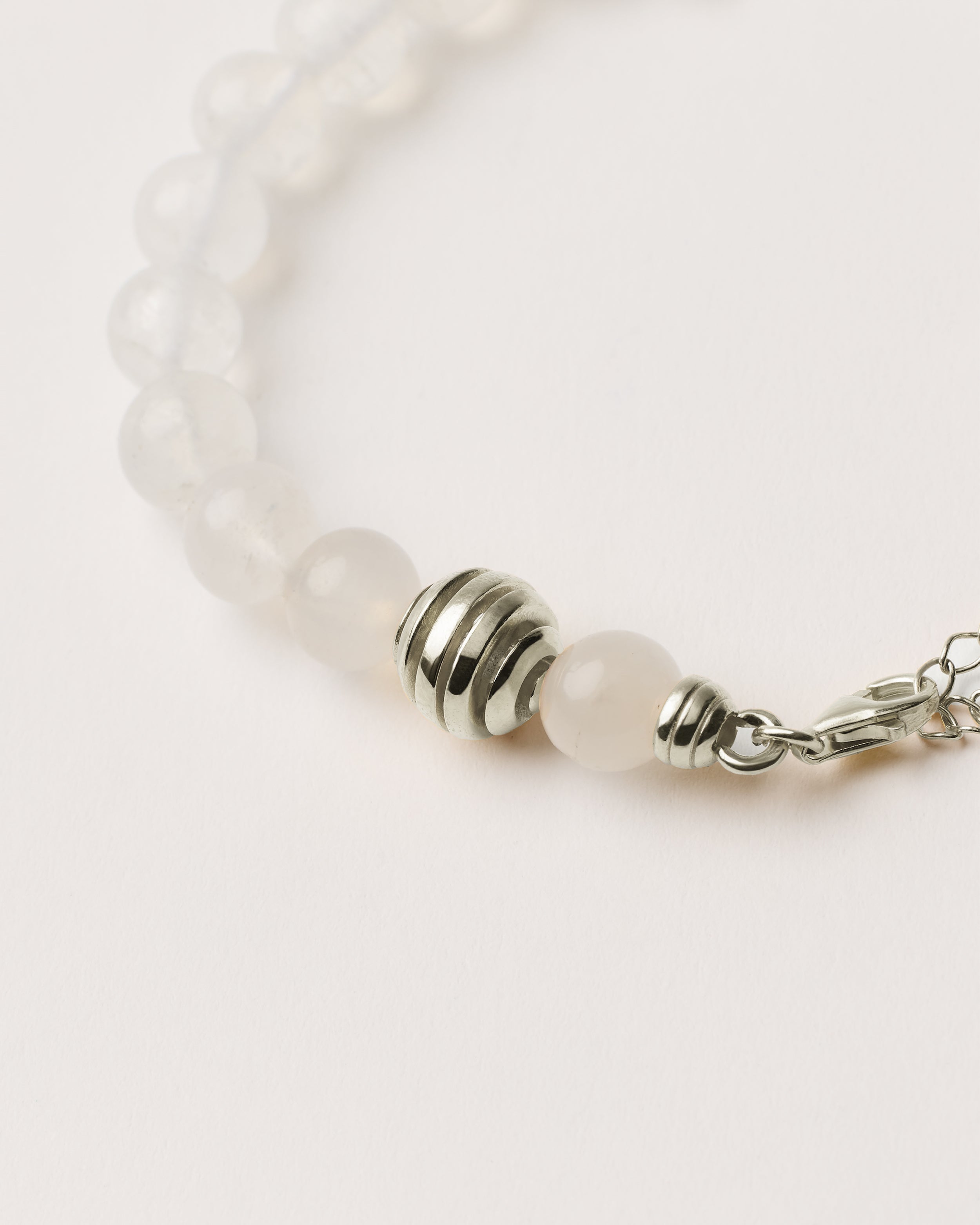 ETERNA LUNOR Moonstone bracelet with polished silver spiral bead, 4 cm extension chain and clasp, arrowhead-shaped fantasy signature, and 8 mm faceted moonstone bead strand.