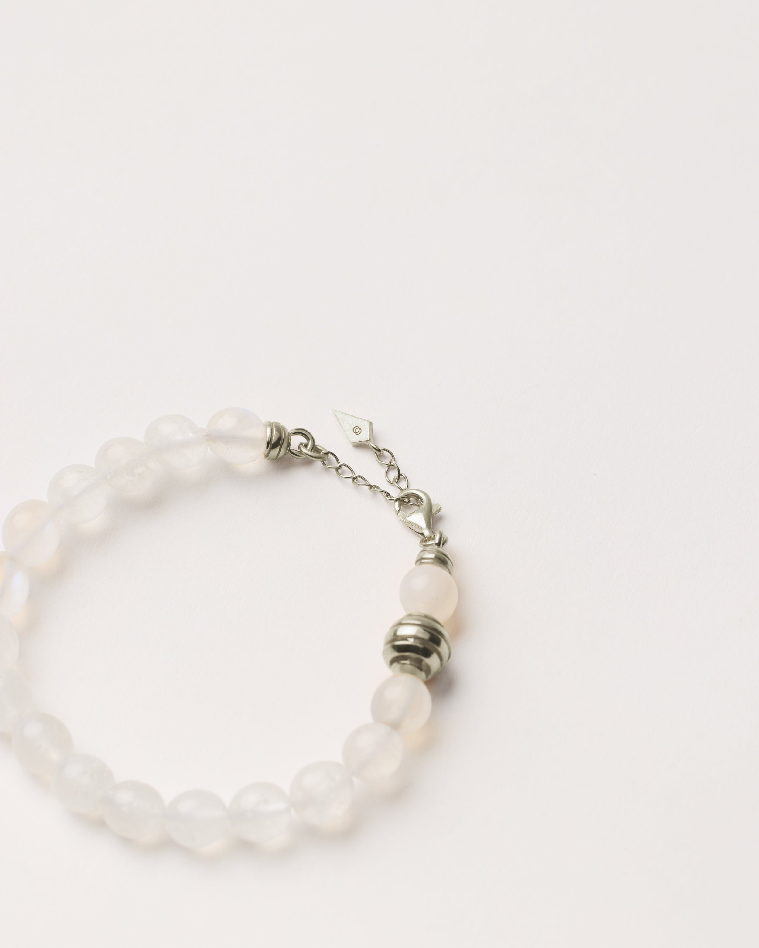 ETERNA LUNOR Moonstone bracelet with polished silver spiral bead, 4 cm extension chain and clasp, arrowhead-shaped fantasy signature, and 8 mm faceted moonstone bead strand.