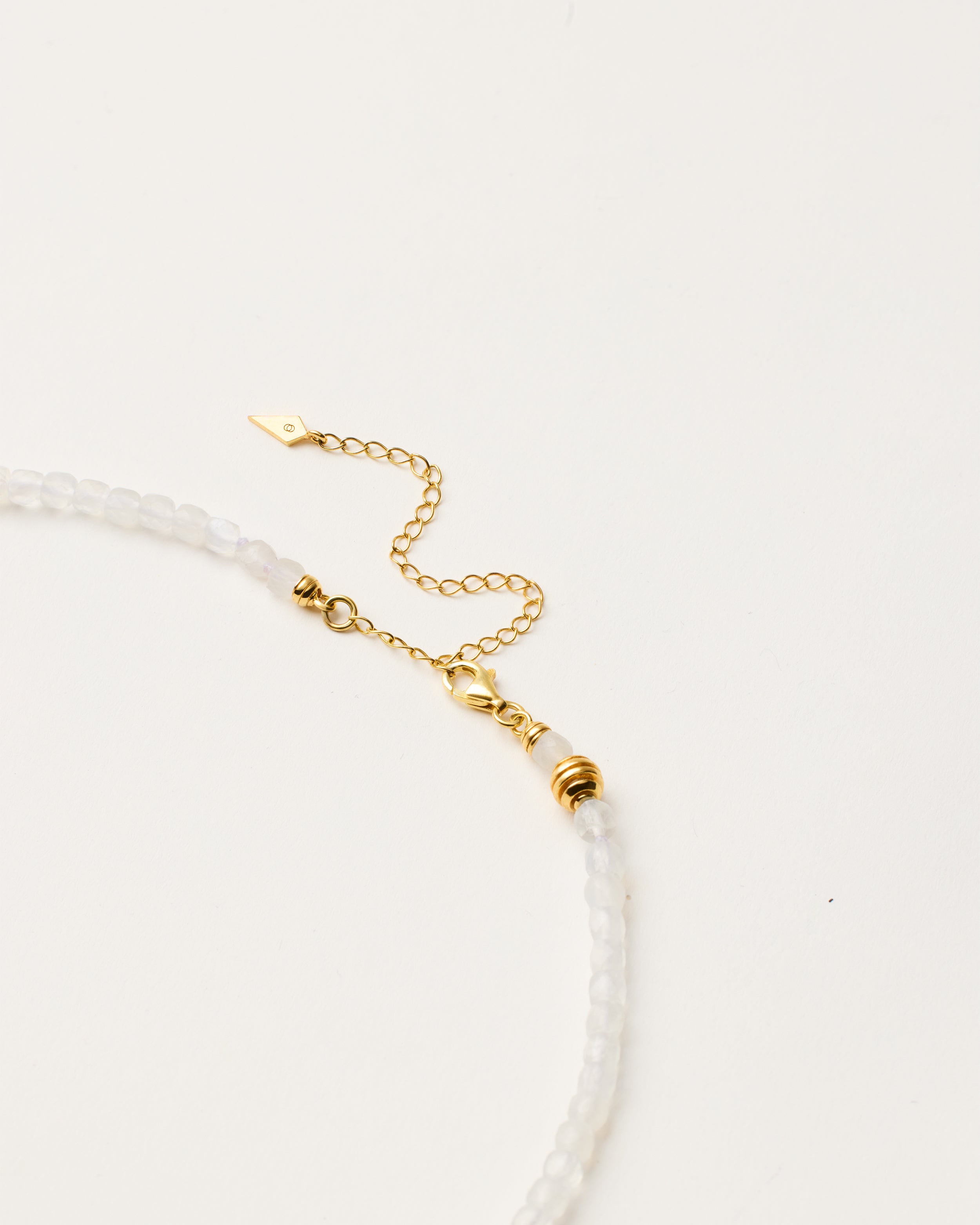 ETERNA LUNOR Moonstone necklace with polished gold-plated silver spiral bead, 8 cm extension chain and clasp, arrowhead-shaped fantasy signature, and 4 mm faceted moonstone bead strand.