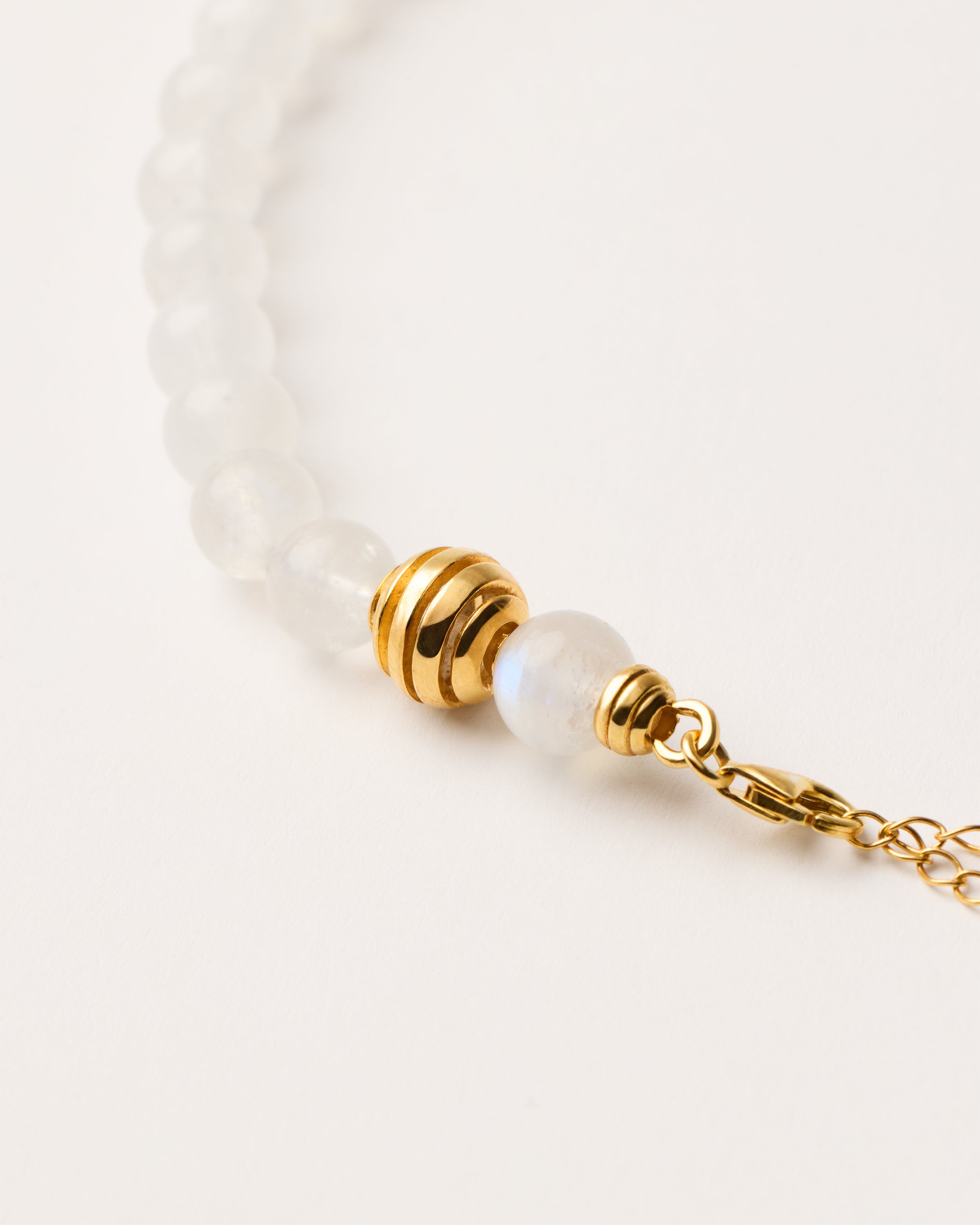 ETERNA LUNOR Moonstone necklace with polished gold-plated silver spiral bead, 8 cm extension chain and clasp, arrowhead-shaped fantasy signature, and 8 mm faceted moonstone bead strand.