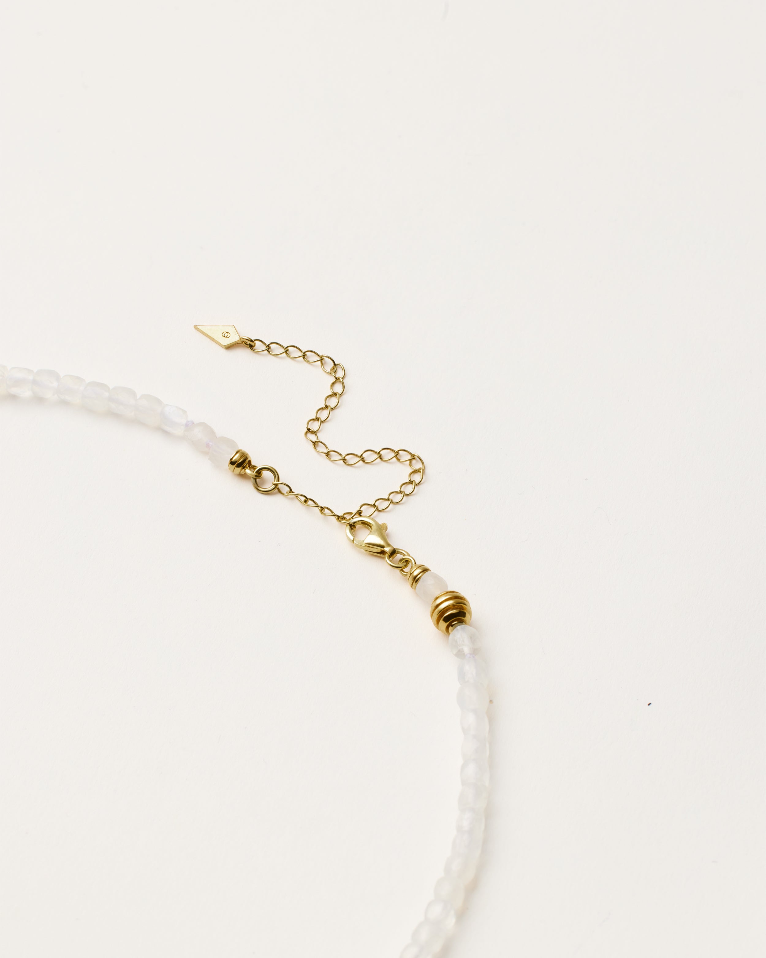 ETERNA LUNOR Moonstone necklace with polished gold spiral bead, 8 cm extension chain and clasp, arrowhead-shaped fantasy signature, and 4 mm faceted moonstone bead strand.