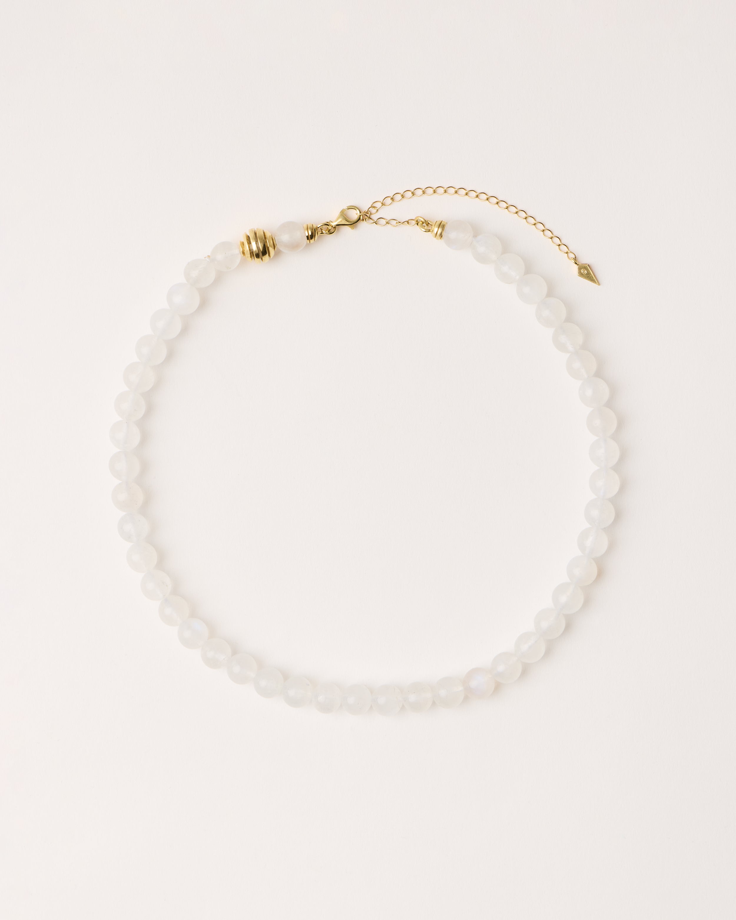 ETERNA LUNOR Moonstone necklace with polished gold spiral bead, 8 cm extension chain and clasp, arrowhead-shaped fantasy signature, and 8 mm faceted moonstone bead strand.