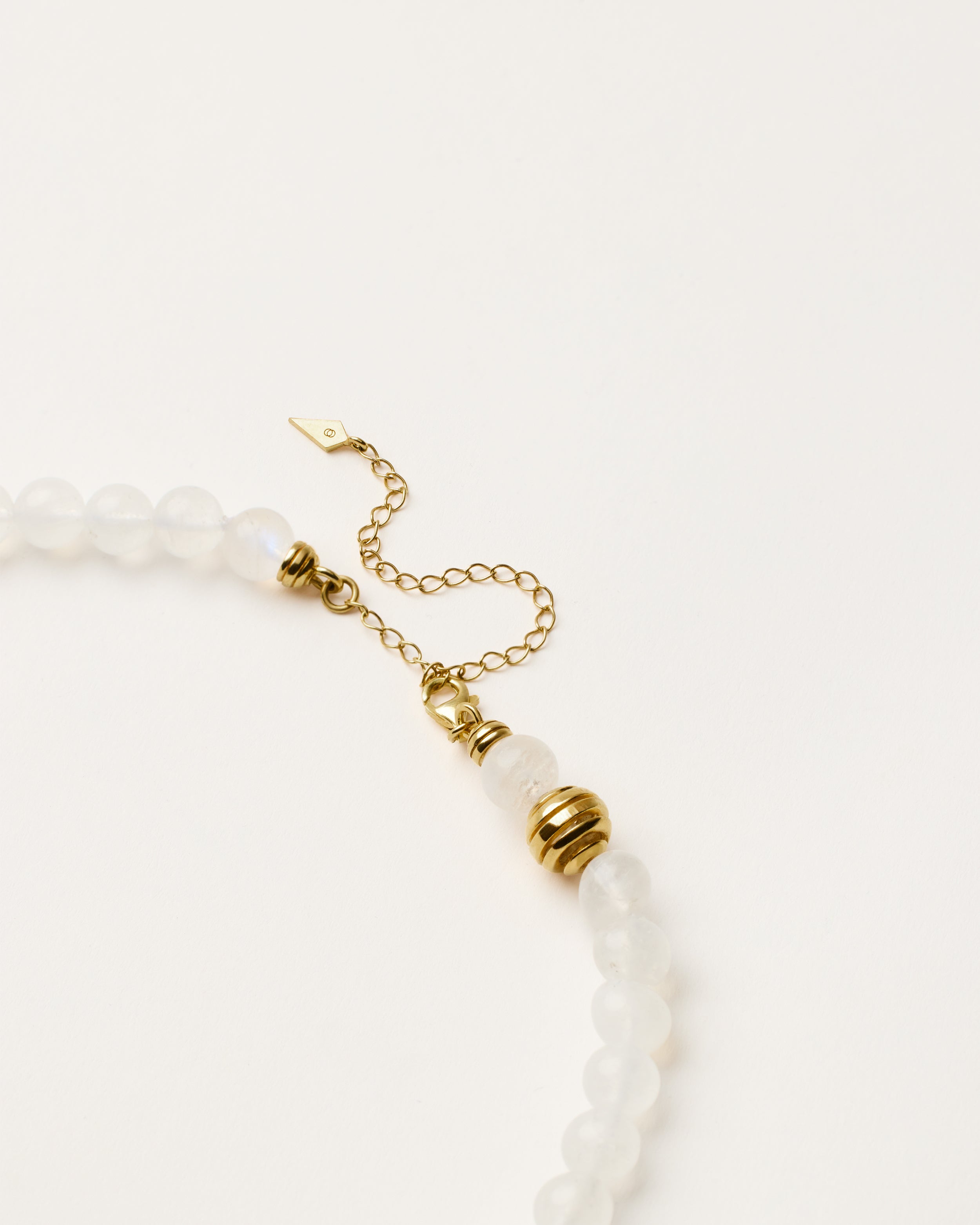 ETERNA LUNOR Moonstone necklace with polished gold spiral bead, 8 cm extension chain and clasp, arrowhead-shaped fantasy signature, and 8 mm faceted moonstone bead strand.
