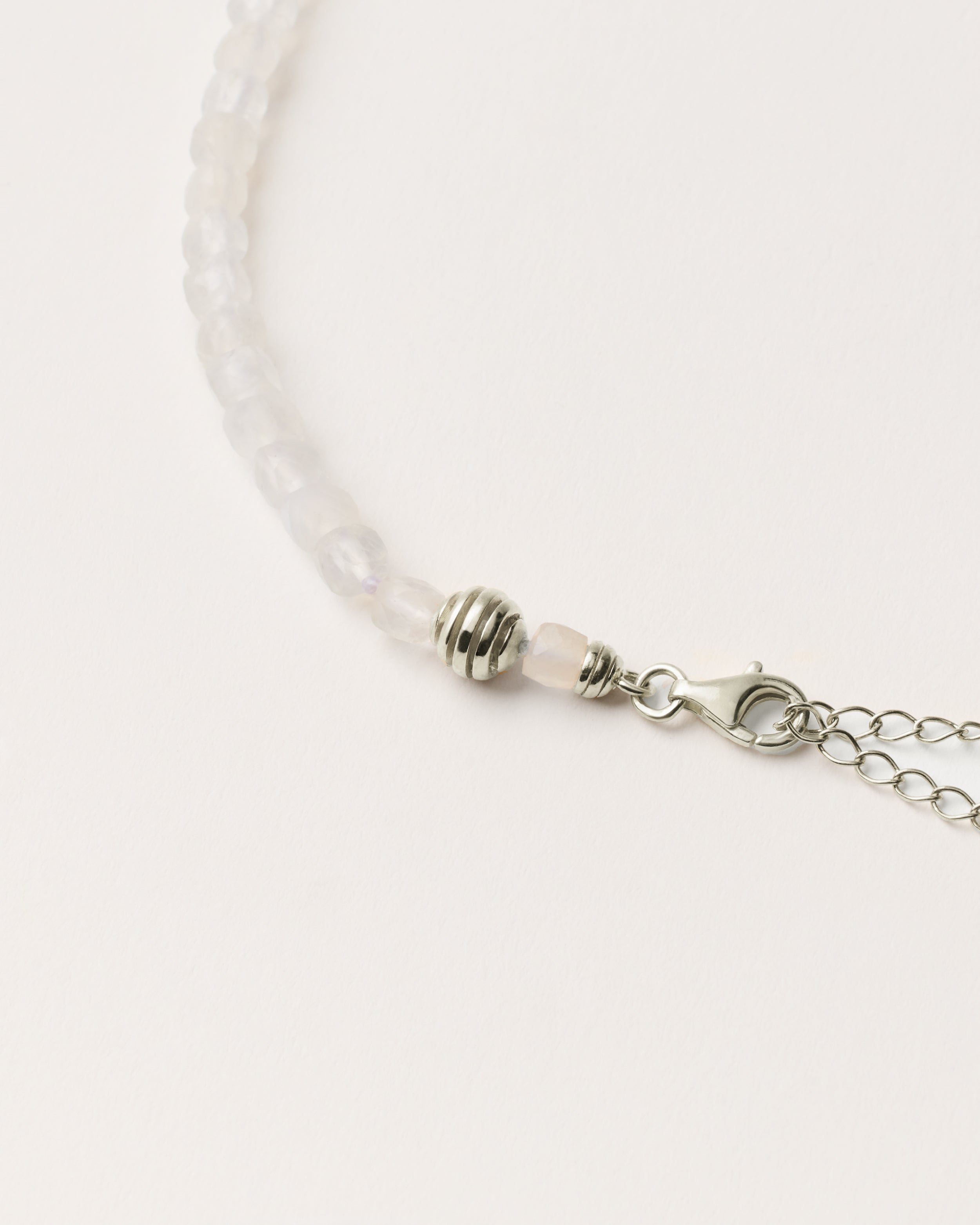 ETERNA LUNOR Moonstone necklace with polished silver spiral bead, 8 cm extension chain and clasp, arrowhead-shaped fantasy signature, and 4 mm faceted moonstone bead strand.