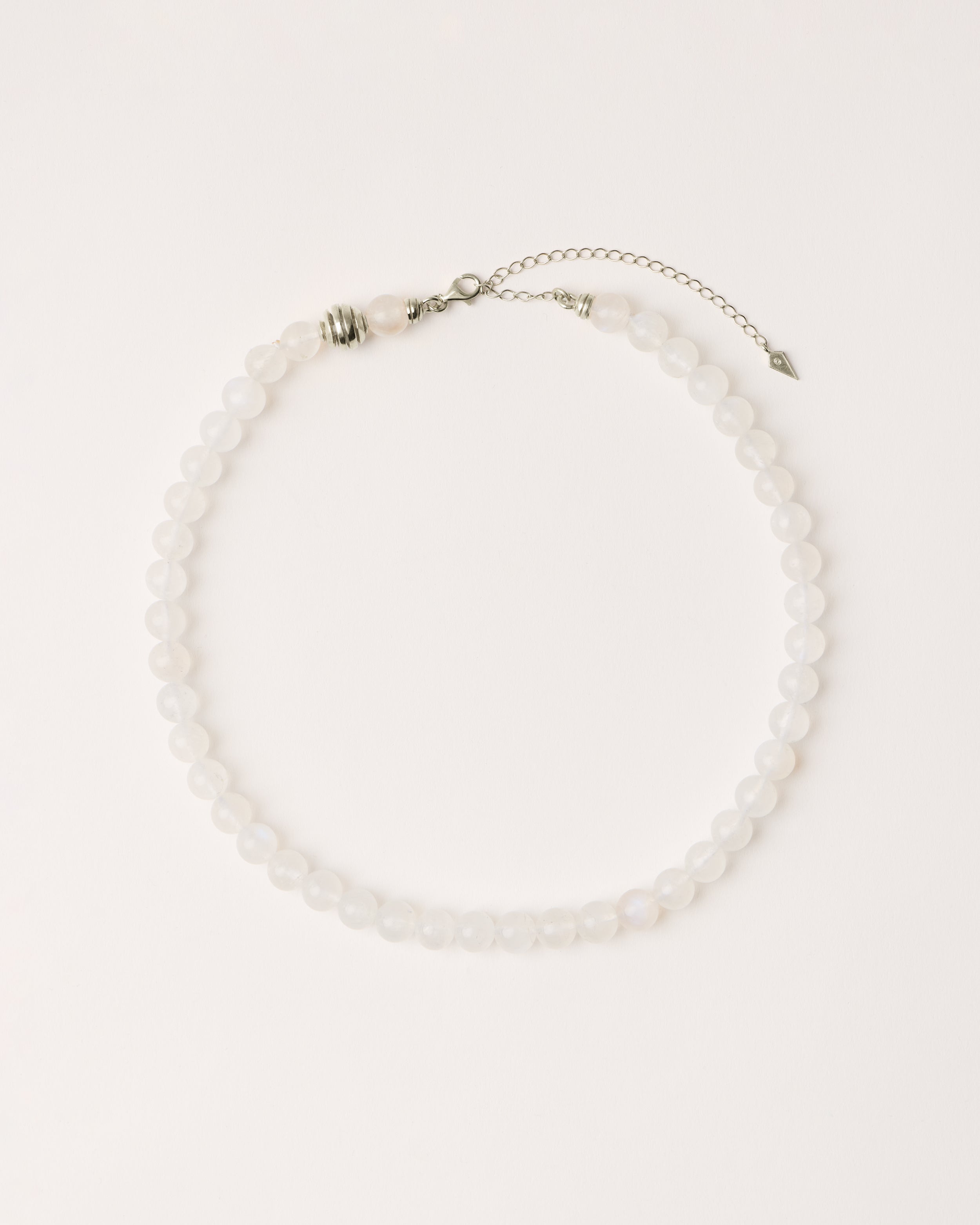 ETERNA LUNOR Moonstone necklace with polished silver spiral bead, 8 cm extension chain and clasp, arrowhead-shaped fantasy signature, and 8 mm faceted moonstone bead strand.