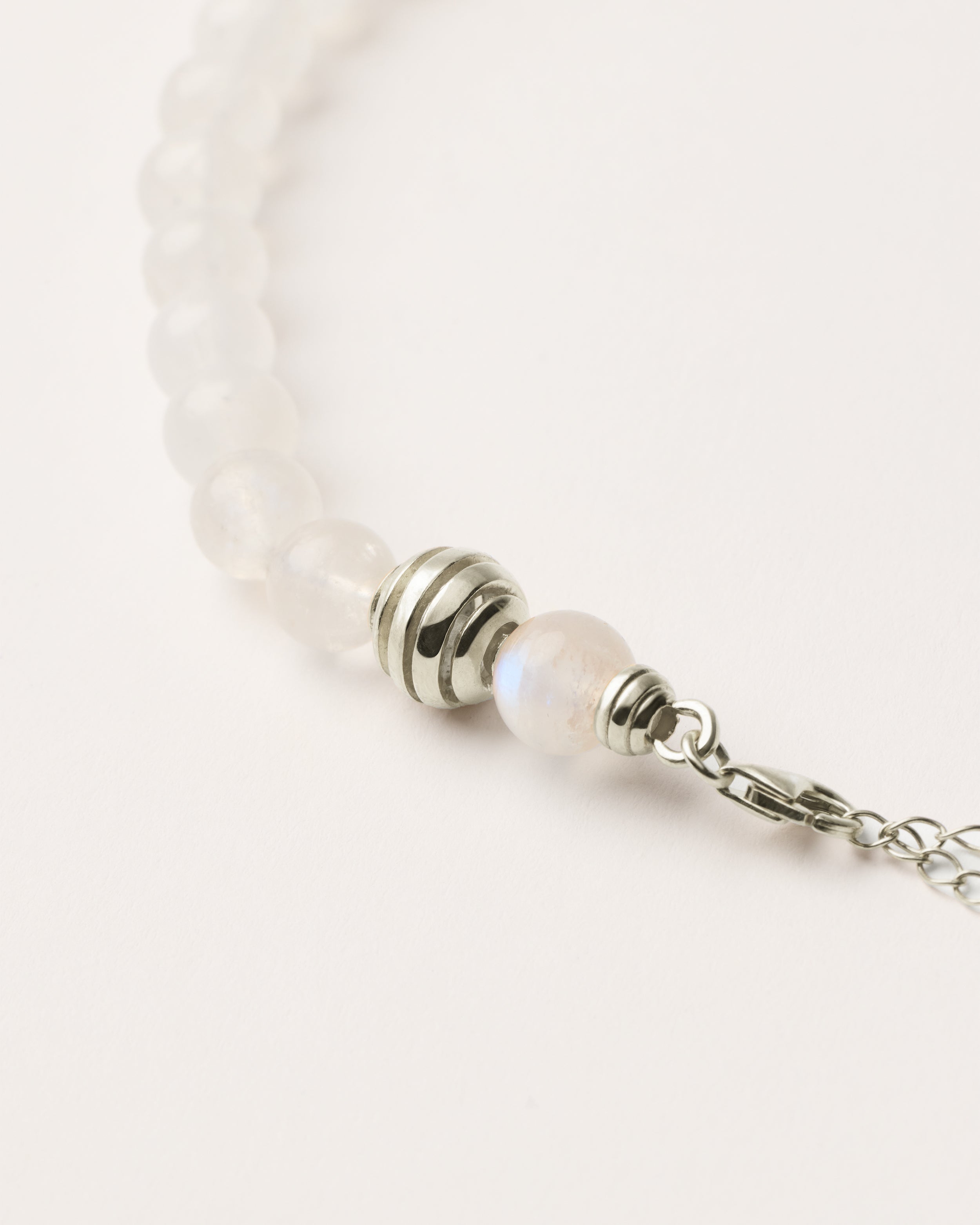 ETERNA LUNOR Moonstone necklace with polished silver spiral bead, 8 cm extension chain and clasp, arrowhead-shaped fantasy signature, and 8 mm faceted moonstone bead strand.