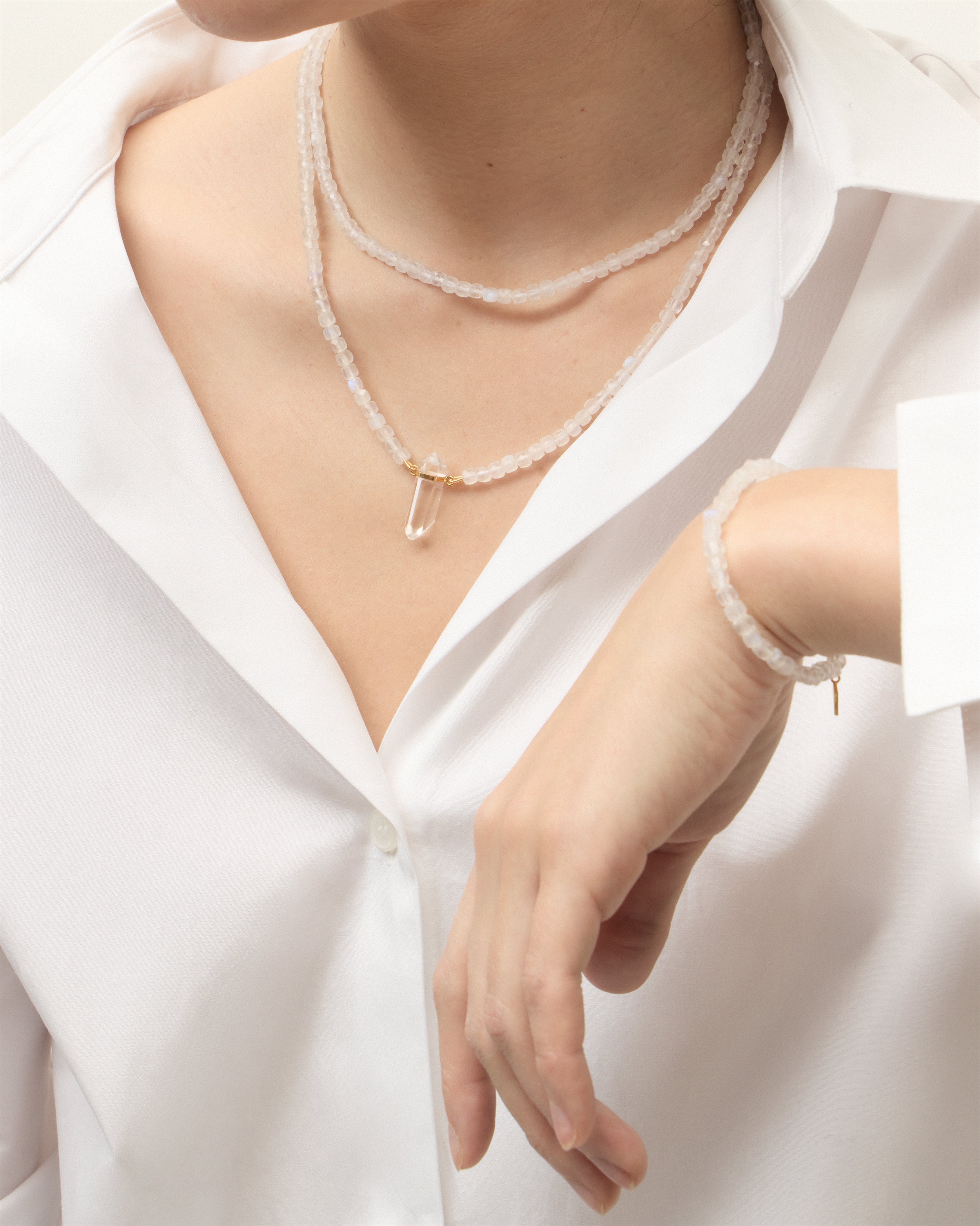 ENCARA / ETERNA LUNOR Moonstone necklaces and bracelet with polished gold spiral bead, extension chain and clasp, arrowhead-shaped fantasy signature, and 4 mm faceted moonstone bead strand and raw polished quartz point pendant.