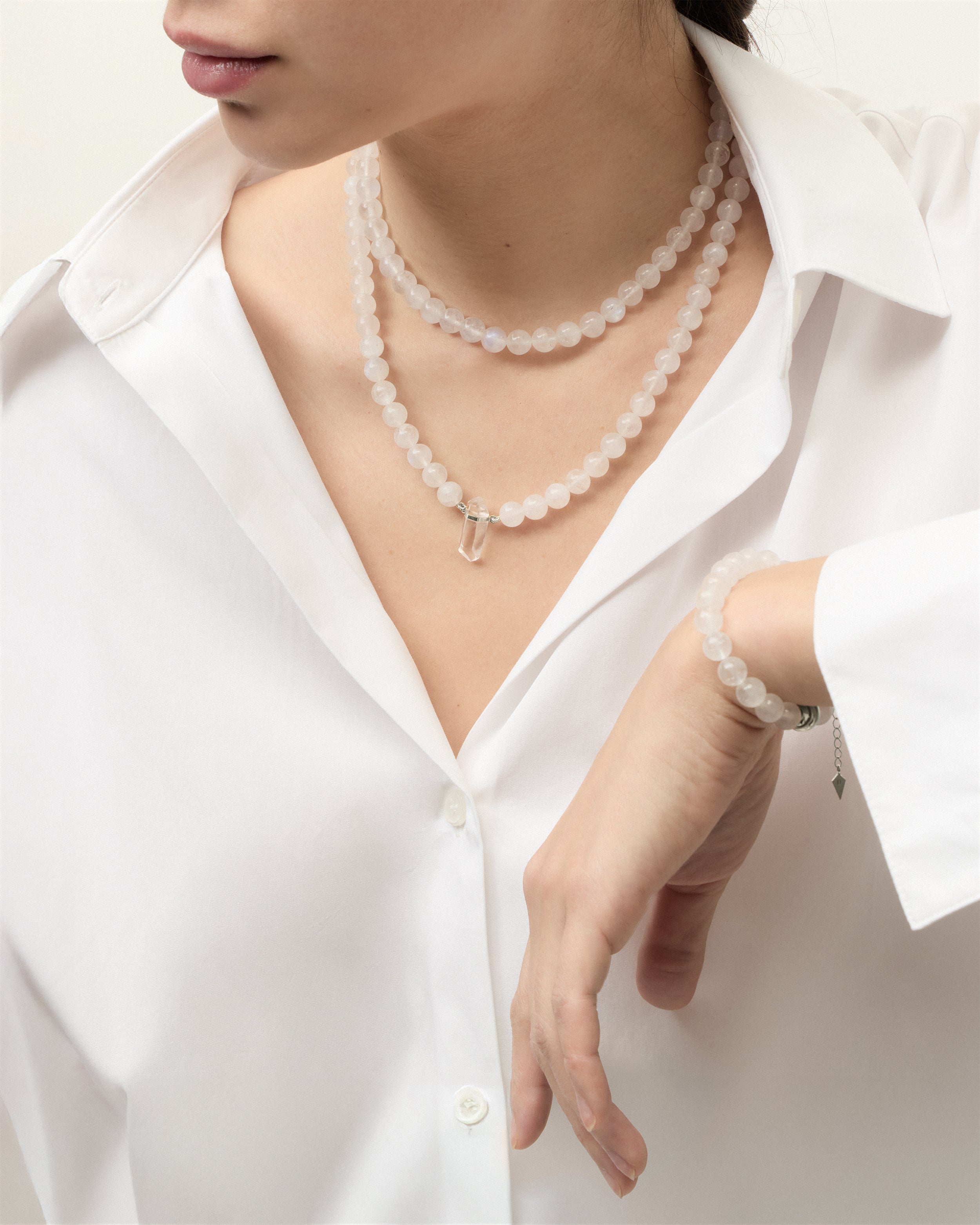 ENCARA / ETERNA LUNOR Moonstone necklaces and bracelet with polished silver spiral bead, extension chain and clasp, arrowhead-shaped fantasy signature, and 8 mm faceted moonstone bead strand and raw polished quartz point pendant.