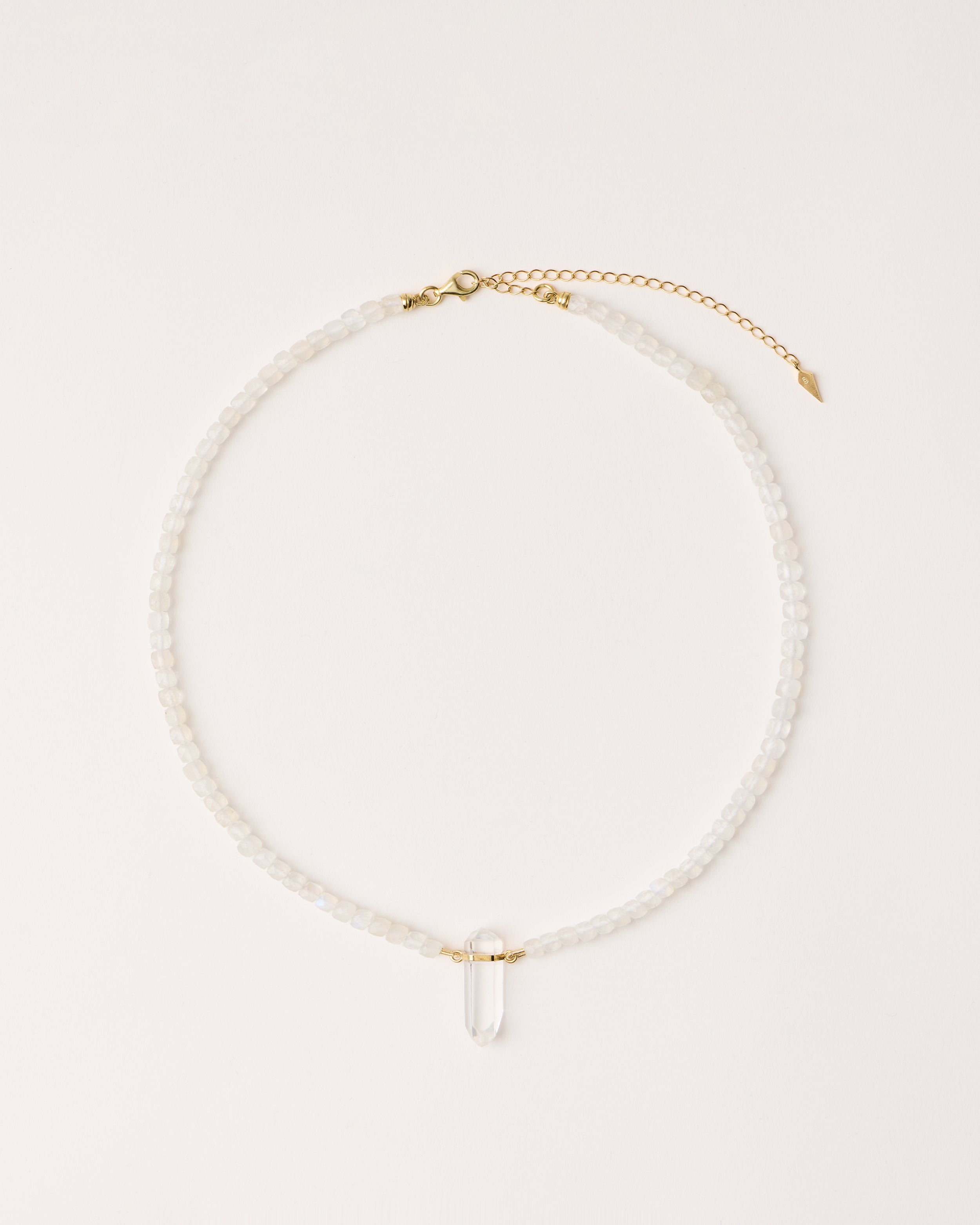 ENCARA LUNOR Moonstone necklace with raw polished quartz point pendant, gold 8 cm extension chain and clasp, arrowhead-shaped fantasy signature, and 4 mm faceted moonstone bead strand.