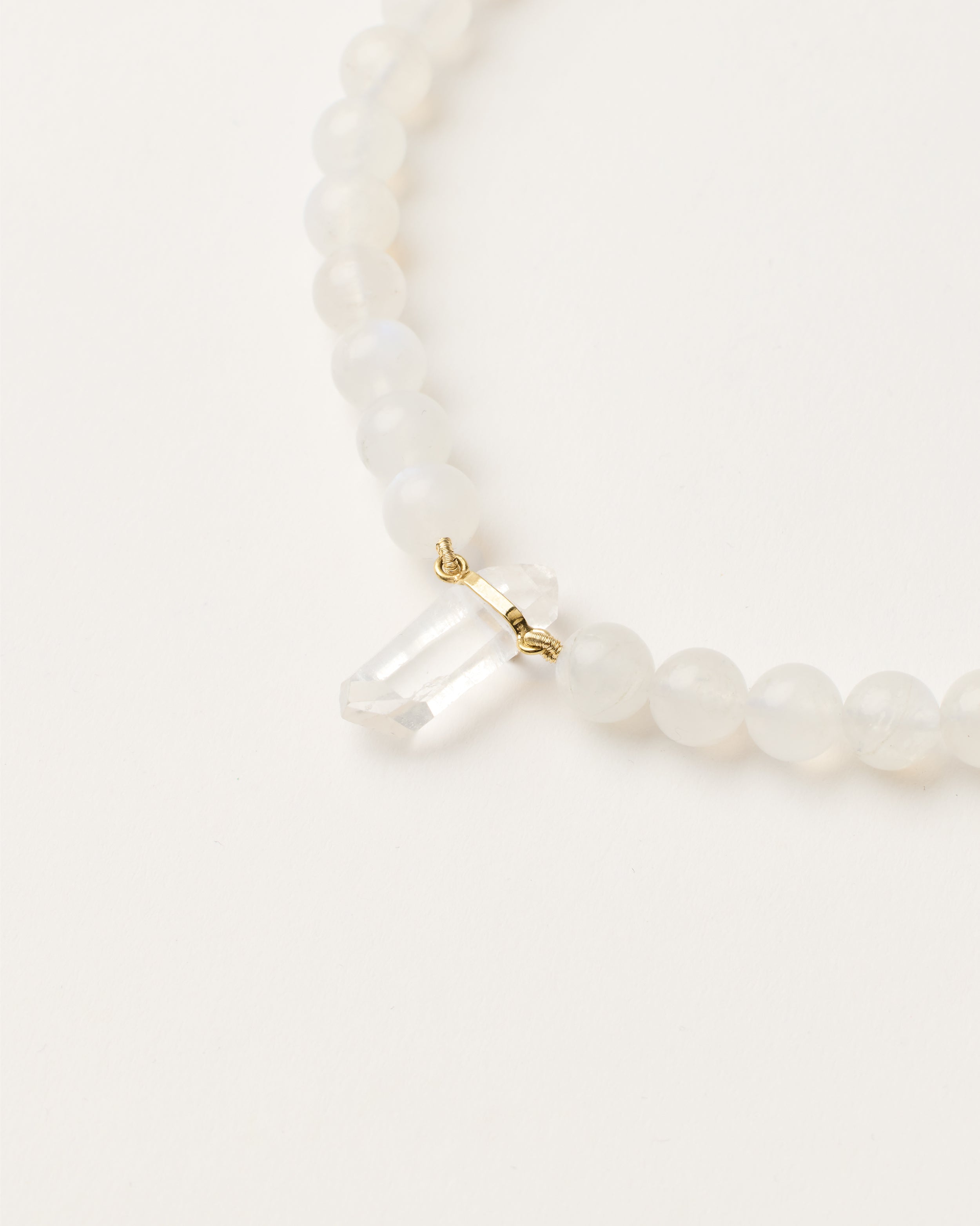 ENCARA LUNOR Moonstone necklace with raw polished quartz point pendant, gold 8 cm extension chain and clasp, arrowhead-shaped fantasy signature, and 8 mm faceted moonstone bead strand.