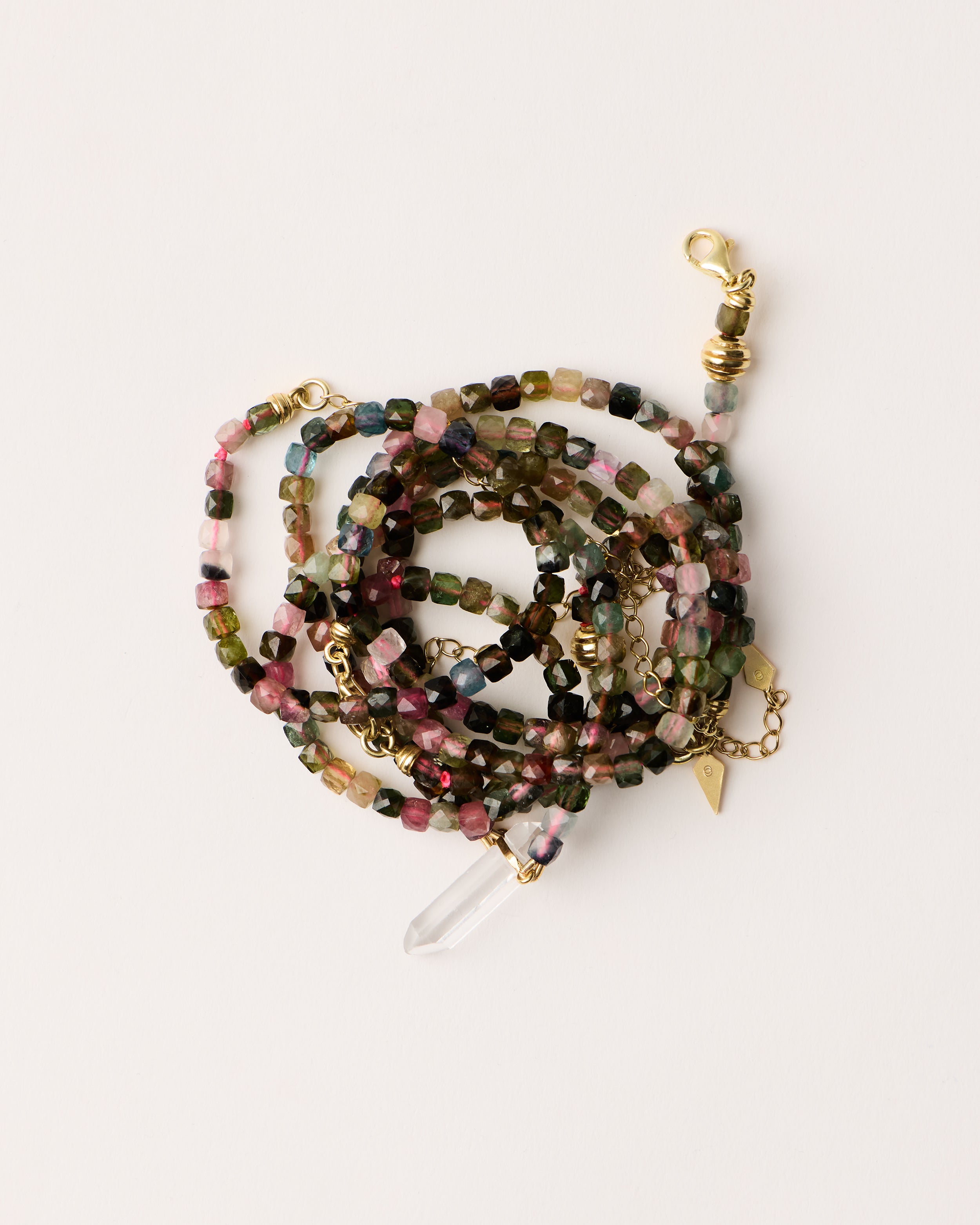 ENCARA / ETERNA AURIL Tourmaline necklaces and bracelet with polished gold spiral bead, extension chain and clasp, arrowhead-shaped fantasy signature, and 4 mm faceted tourmaline bead strand and raw polished quartz point pendant.