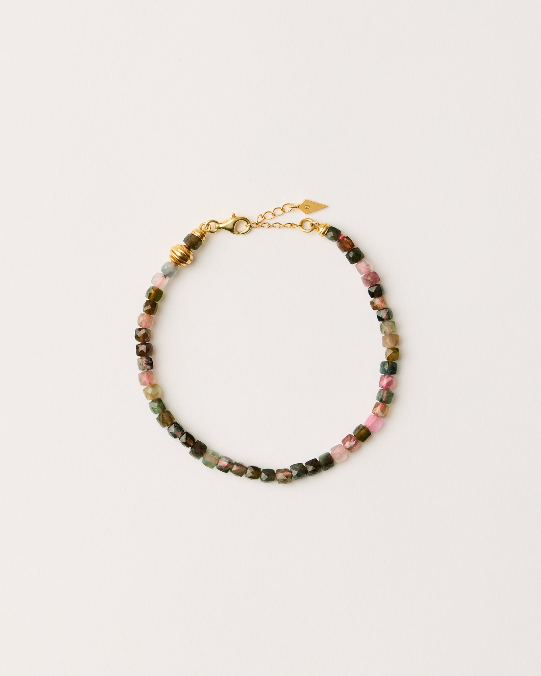 ETERNA AURIL Tourmaline bracelet with polished gold-plated silver spiral bead, 4 cm extension chain and clasp, arrowhead-shaped fantasy signature, and 4 mm faceted tourmaline bead strand.