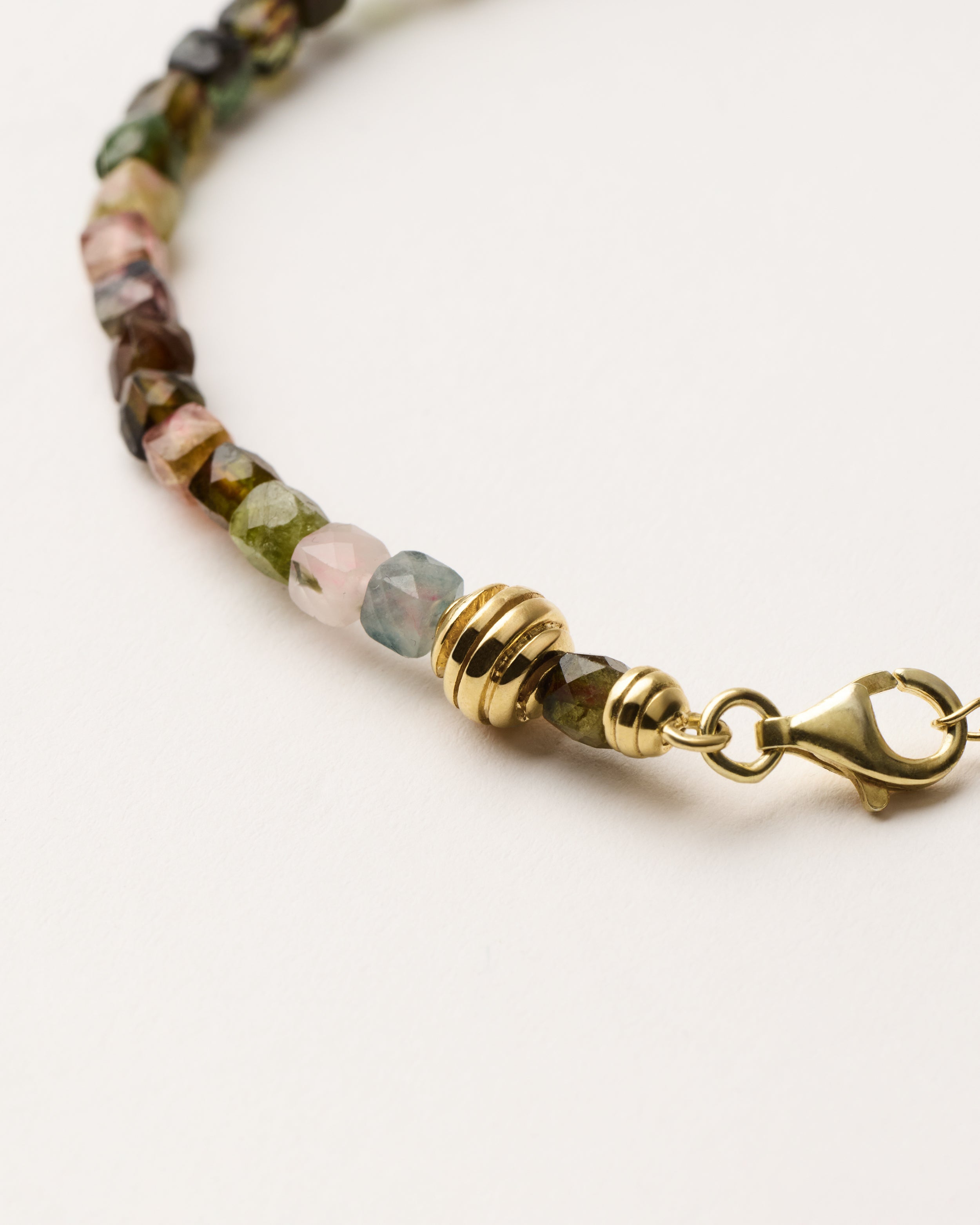 ETERNA AURIL Tourmaline bracelet with polished gold spiral bead, 4 cm extension chain and clasp, arrowhead-shaped fantasy signature, and 4 mm faceted tourmaline bead strand.
