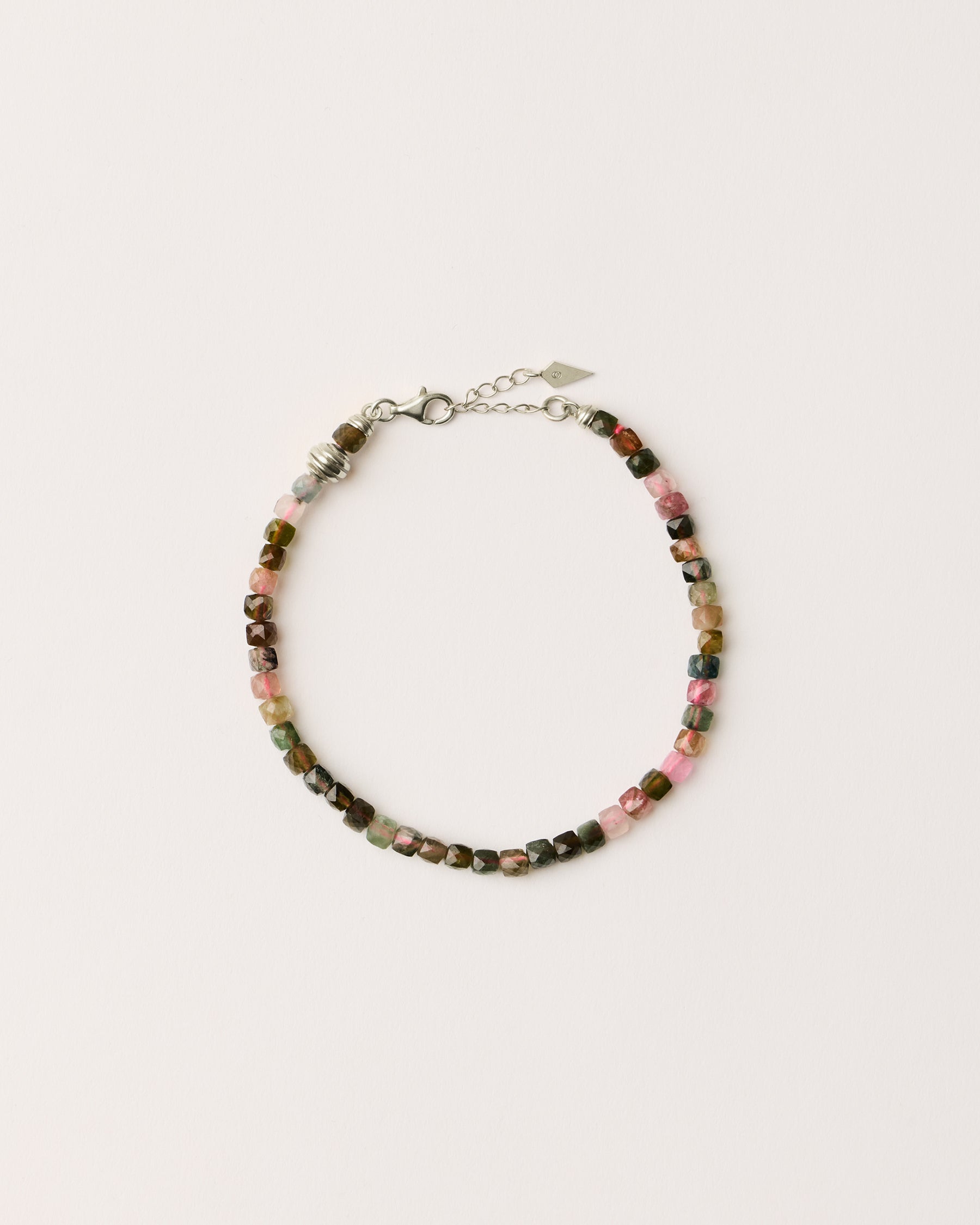 ETERNA AURIL Tourmaline bracelet with polished silver spiral bead, 4 cm extension chain and clasp, arrowhead-shaped fantasy signature, and 4 mm faceted tourmaline bead strand.