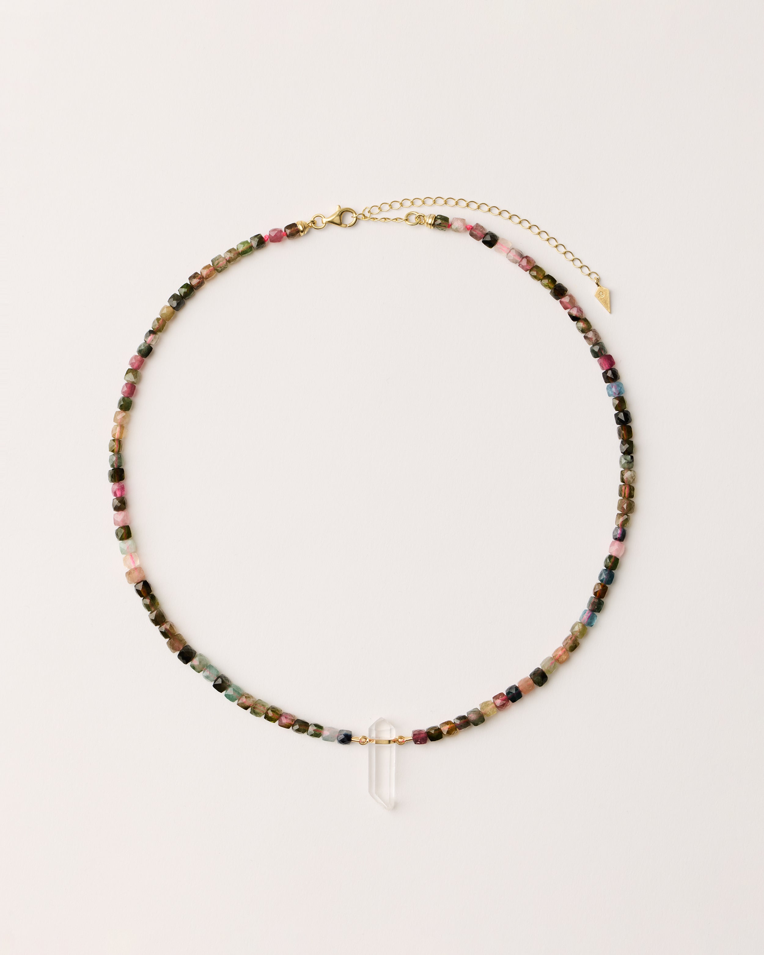 ENCARA AURIL Tourmaline necklace with raw polished quartz point pendant, gold 8 cm extension chain and clasp, arrowhead-shaped fantasy signature, and 4 mm faceted tourmaline bead strand.