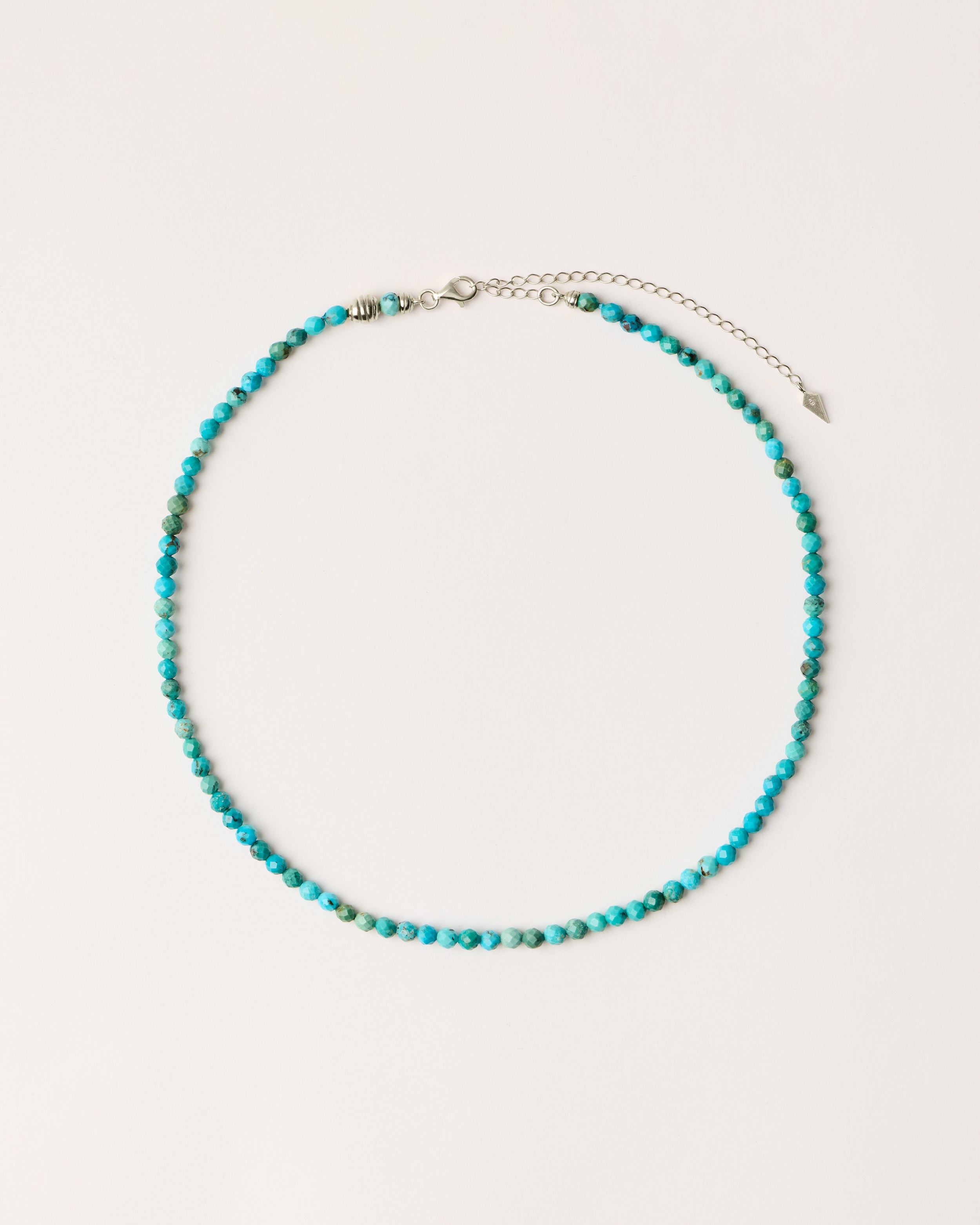 ETERNA AZURA Turquoise necklace with polished silver spiral bead, 8 cm extension chain and clasp, arrowhead-shaped fantasy signature, and 4 mm faceted turquoise bead strand.