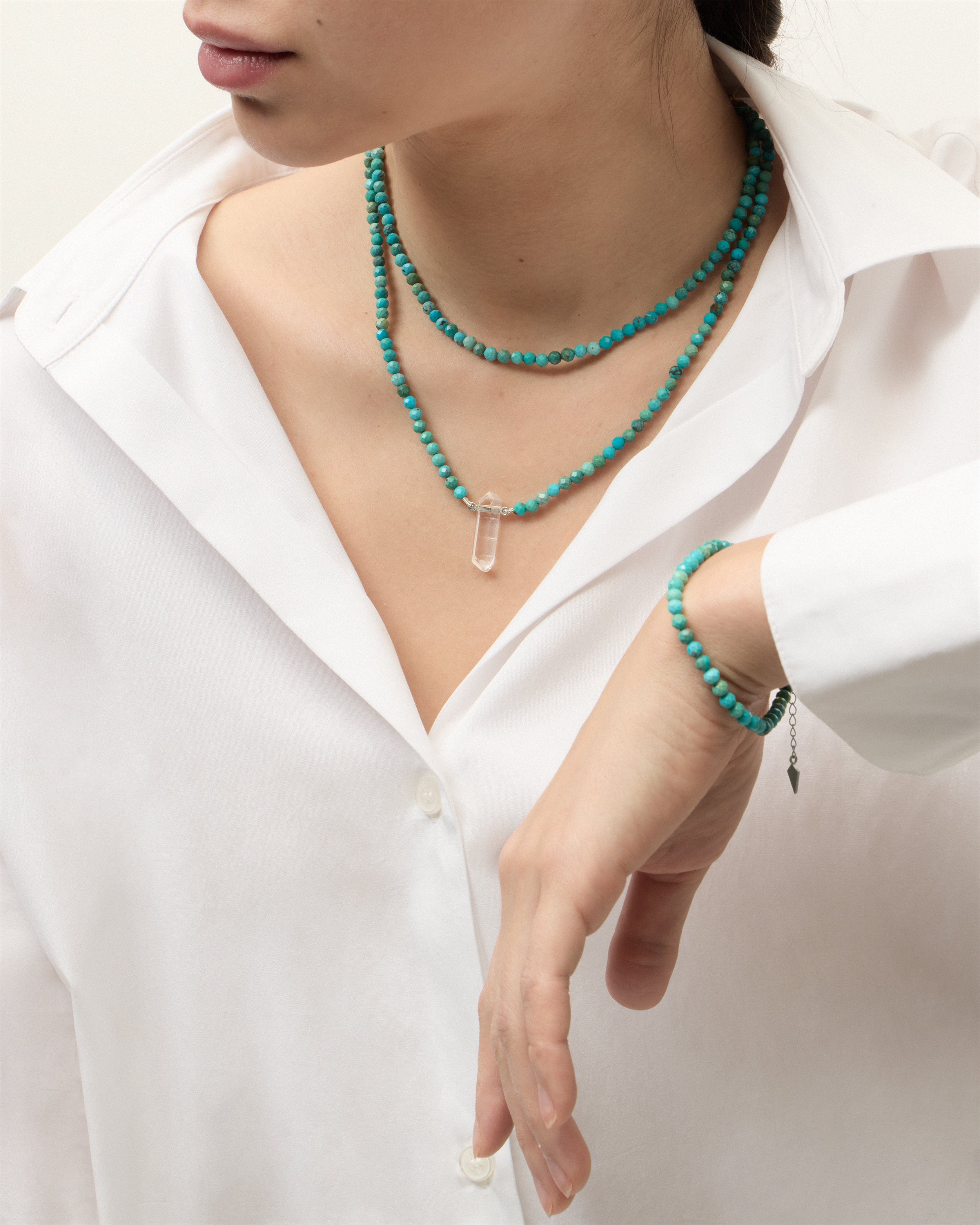 ENCARA / ETERNA AZURA Turquoise necklaces and bracelet with polished silver spiral bead, extension chain and clasp, arrowhead-shaped fantasy signature, and 4 mm faceted turquoise bead strand and raw polished quartz point pendant.
