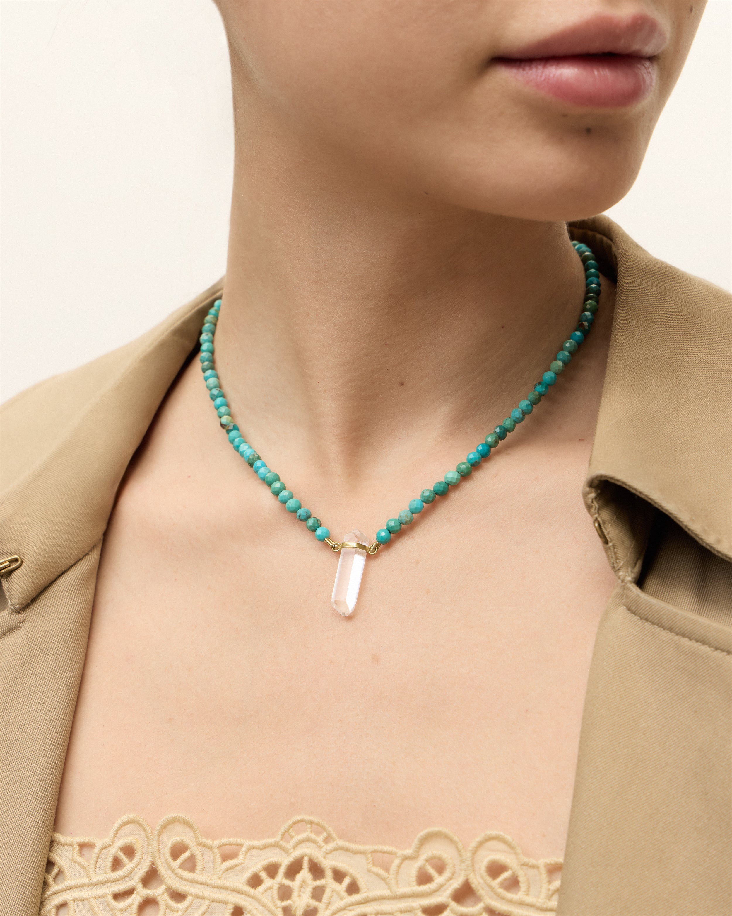 ENCARA AZURA Turquoise necklace with raw polished quartz point pendant, gold 8 cm extension chain and clasp, arrowhead-shaped fantasy signature, and 4 mm faceted turquoise bead strand.