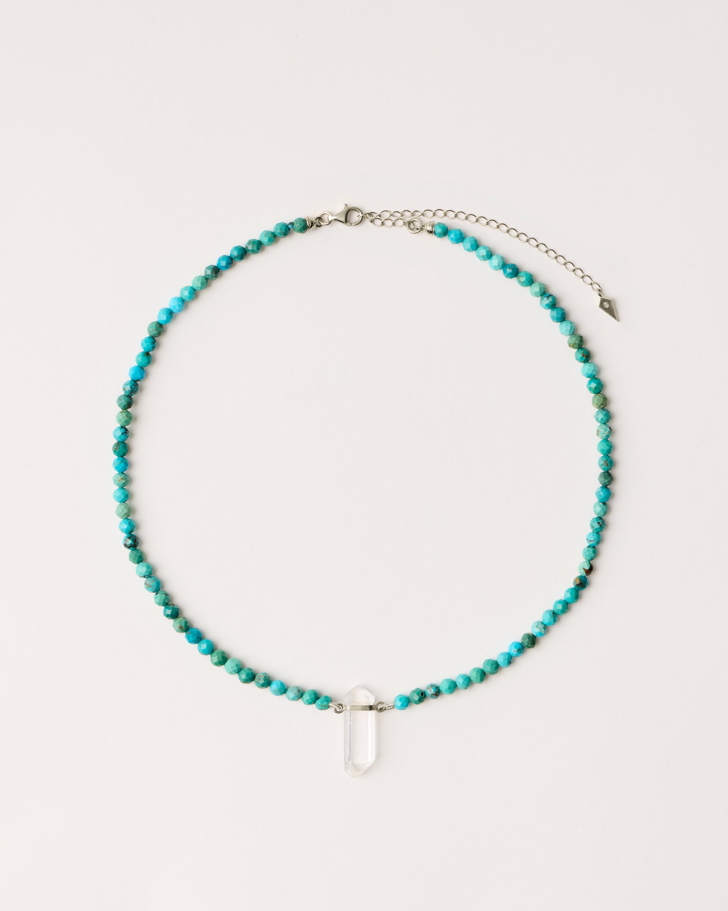 ENCARA AZURA Turquoise necklace with raw polished quartz point pendant, silver 8 cm extension chain and clasp, arrowhead-shaped fantasy signature, and 4 mm faceted turquoise bead strand.