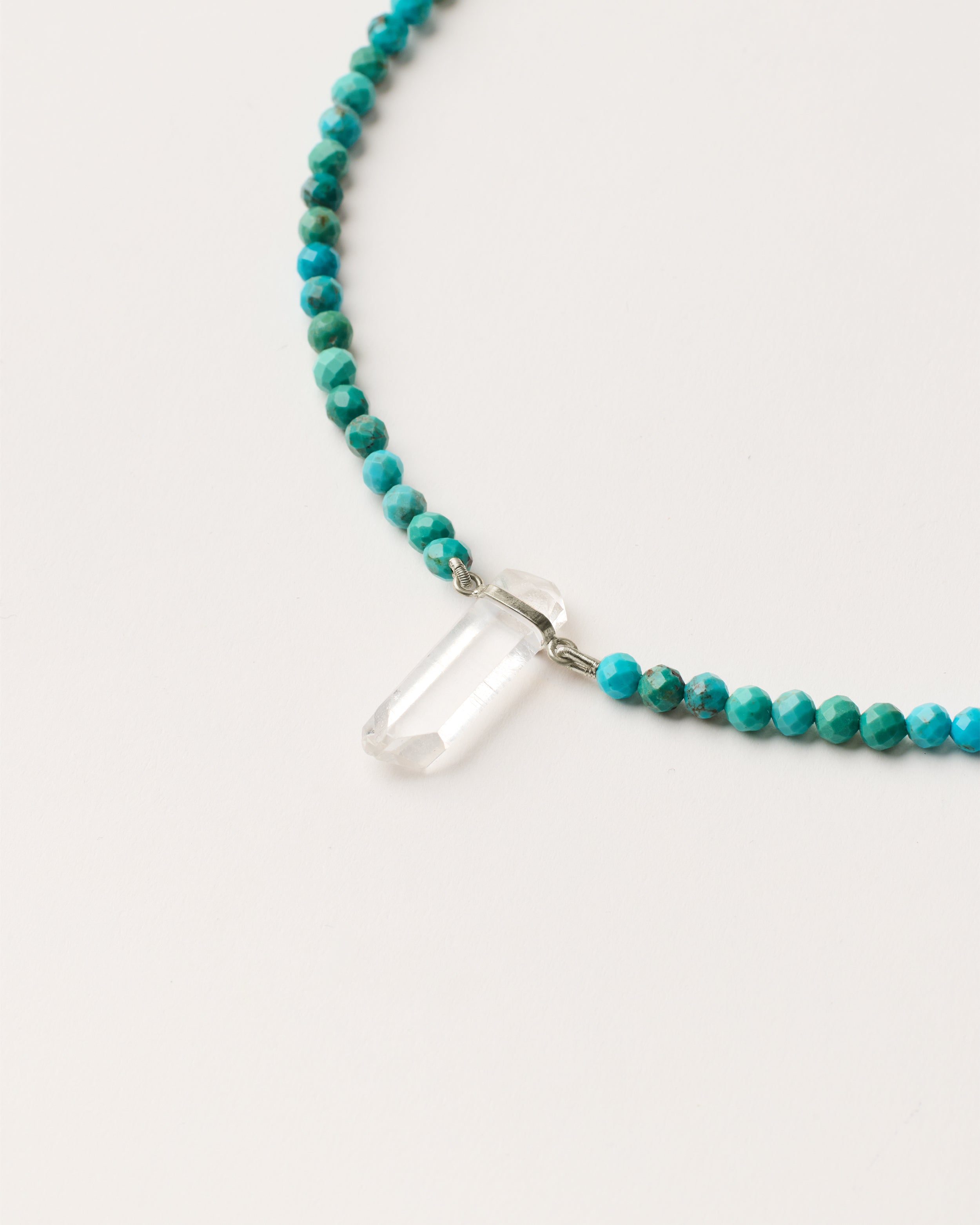 ENCARA AZURA Turquoise necklace with raw polished quartz point pendant, silver 8 cm extension chain and clasp, arrowhead-shaped fantasy signature, and 4 mm faceted turquoise bead strand.